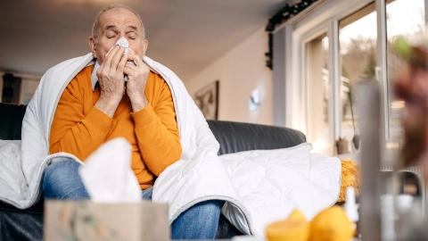 A man with a cold sitting at home.