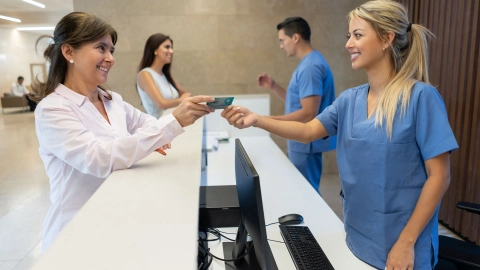 Electronic medical data card – a patient hands over their electronic medical data card to the doctor’s receptionist.