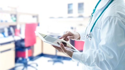 A doctor opening an electronic patient record on a tablet.
