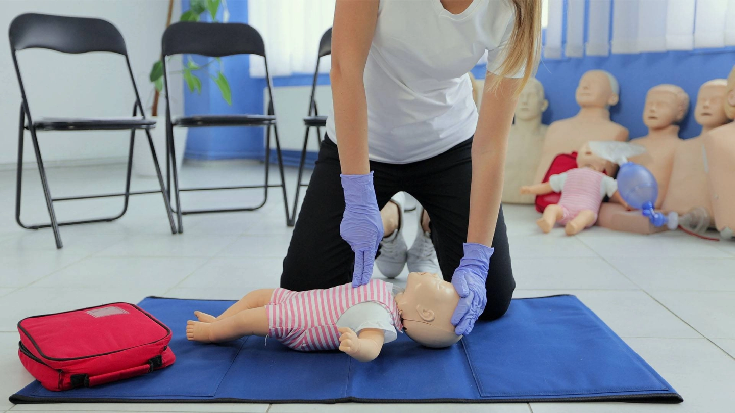 Erste Hilfe bei Kindern (Quelle: iStock/ MyndziakVideo) Frau übt Wiederbelebung an einer Säuglings-Puppe