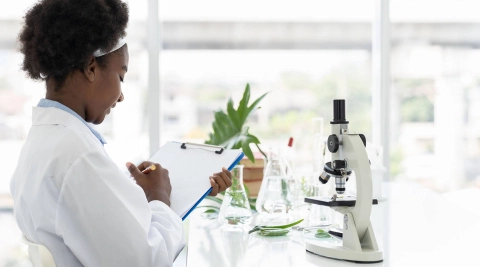 Labormitarbeiterin füllt Formular aus.