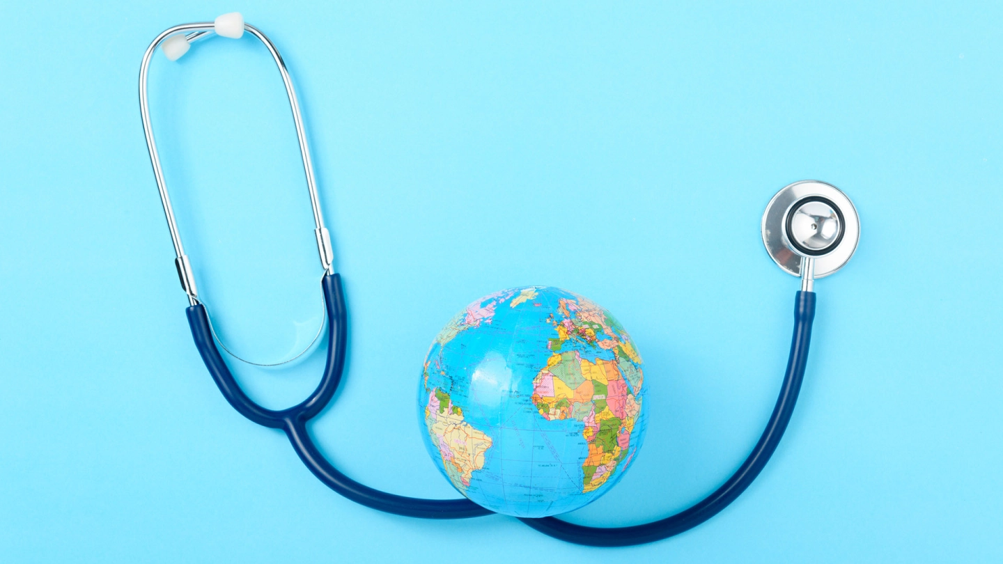 Krank im Ausland (Quelle: iStock/sorapop) Das Bild zeigt ein Stethoskop und einen Globus.
