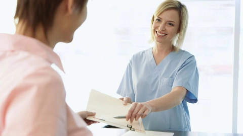 Eine Frau übergibt einer anderen ein Dokument