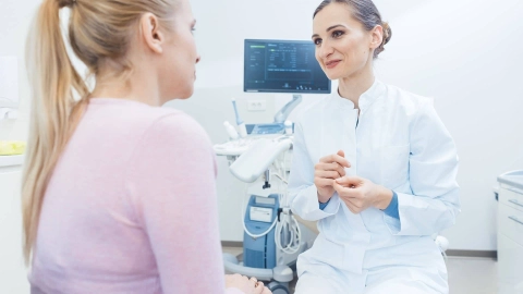 Женщина разговаривает с гинекологом в процедурном кабинете.