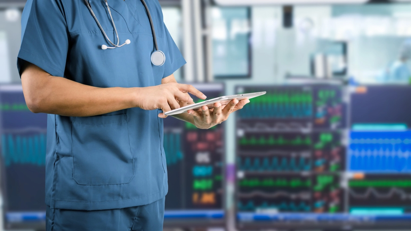 Tele-Schlaganfallstation (Quelle: iStock/sompong_tom) Eine medizinische Fachkraft bedient ein Tablet, im Hintergrund sind Monitore zur Kreislaufüberwachung sichtbar.