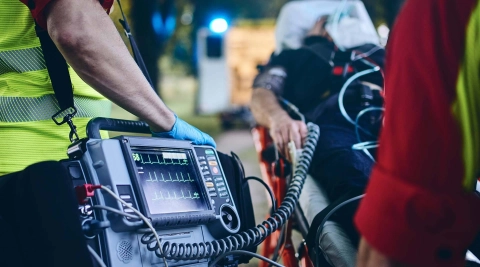 Служба спасения обследует неотложного пациента с помощью ЭКГ.